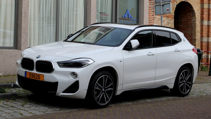 white bmw x2 parked on the side of the street