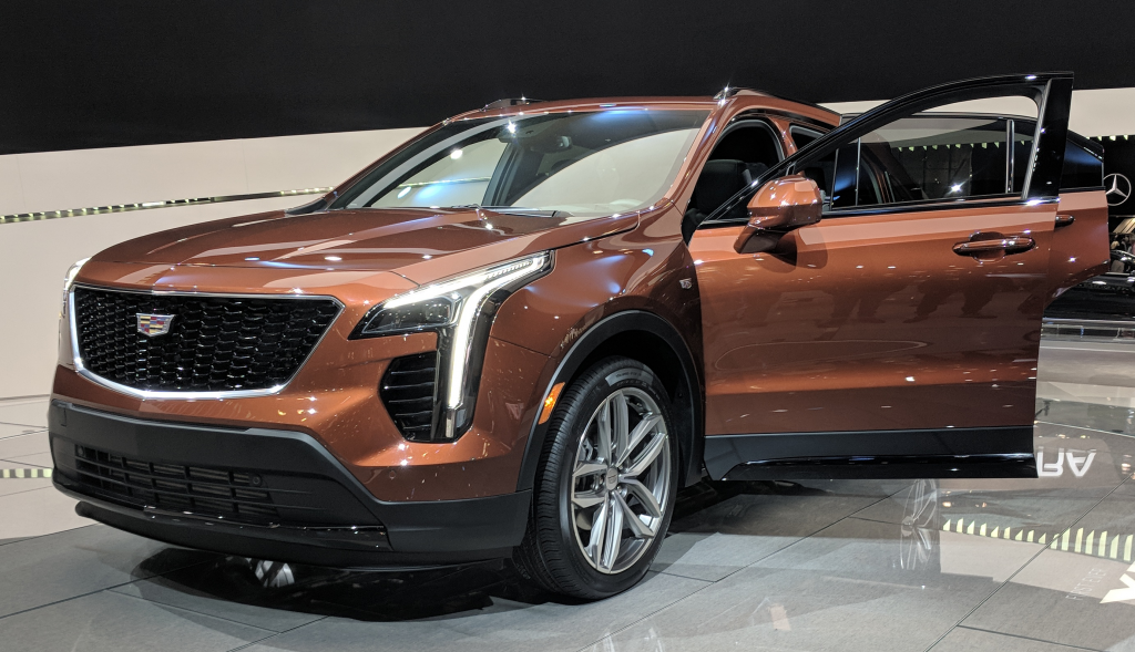 2023 orange cadillac xt4 parked in showroom with driver door open